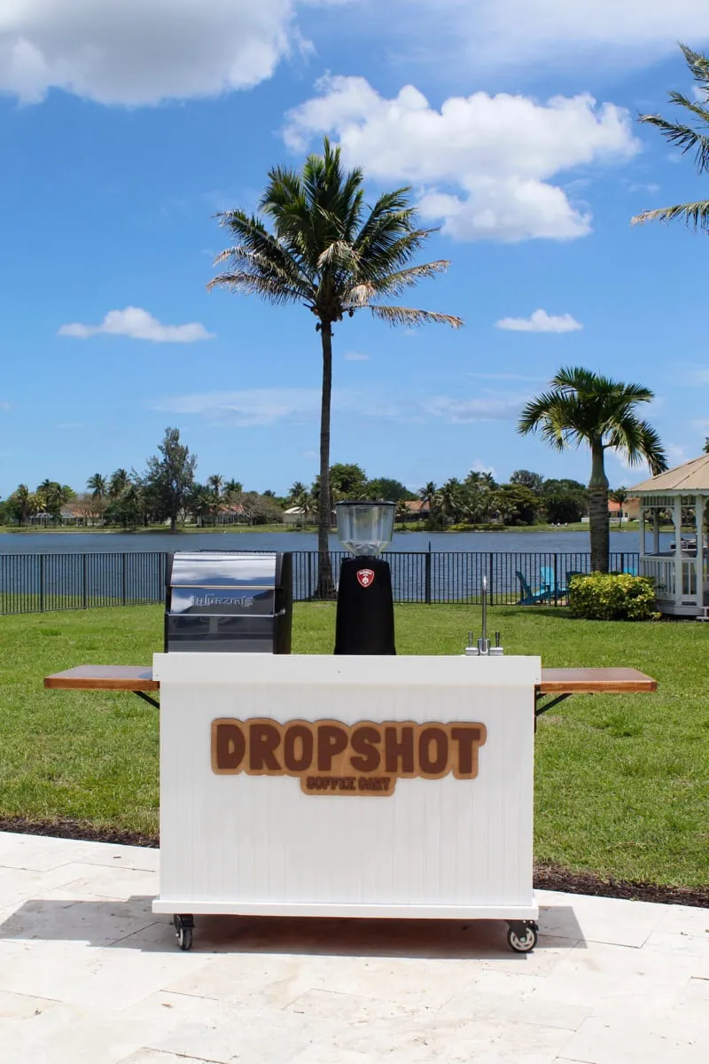 Dropshot Coffee mobile cart with otter logo, espresso machine and grinder